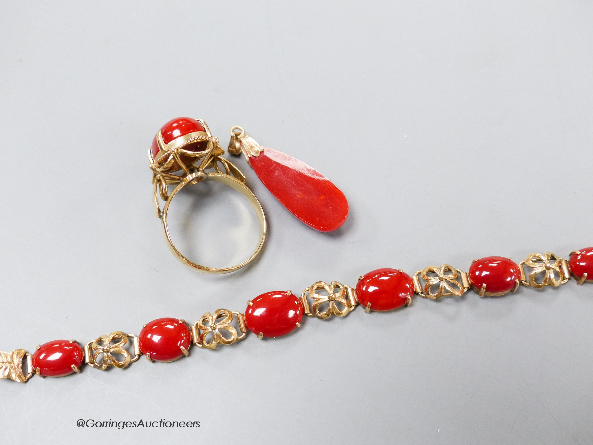 A modern 14k yellow metal mounted coral bracelet, pendant and ring, gross weight 13 grams.